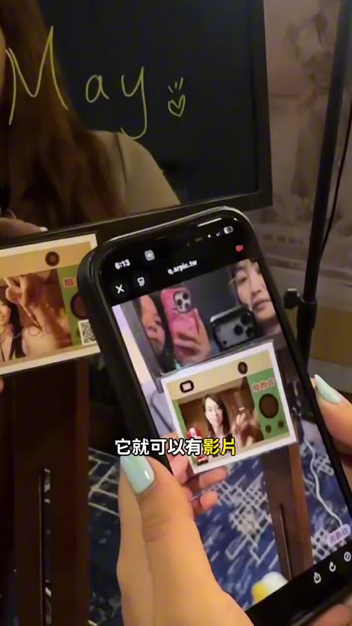 Scanning the QR on a print opens the AR viewer; pointing the camera at the photo makes the video play on it