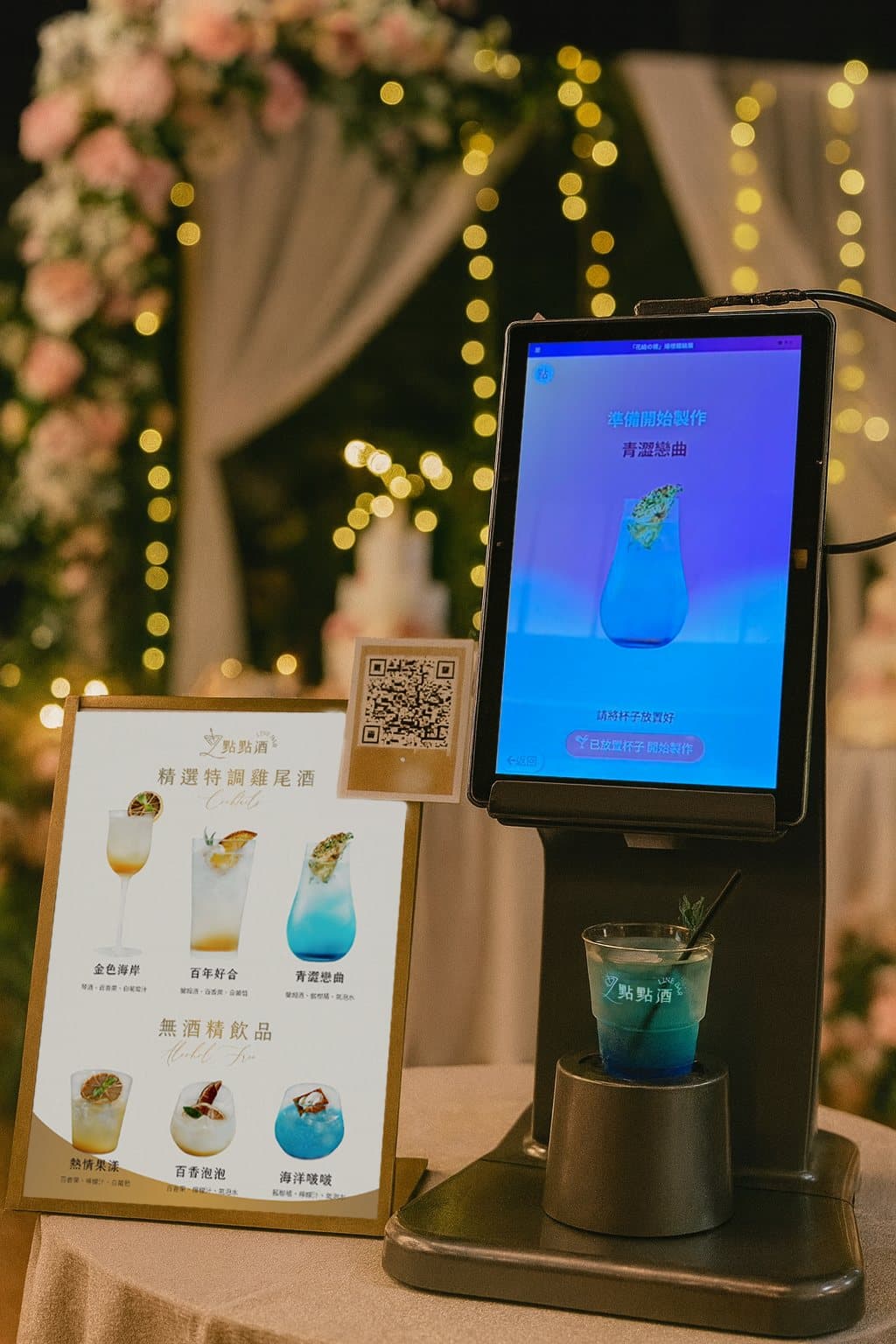 Robot bartender at a wedding, styled with an illustrated drinks menu and flower wall