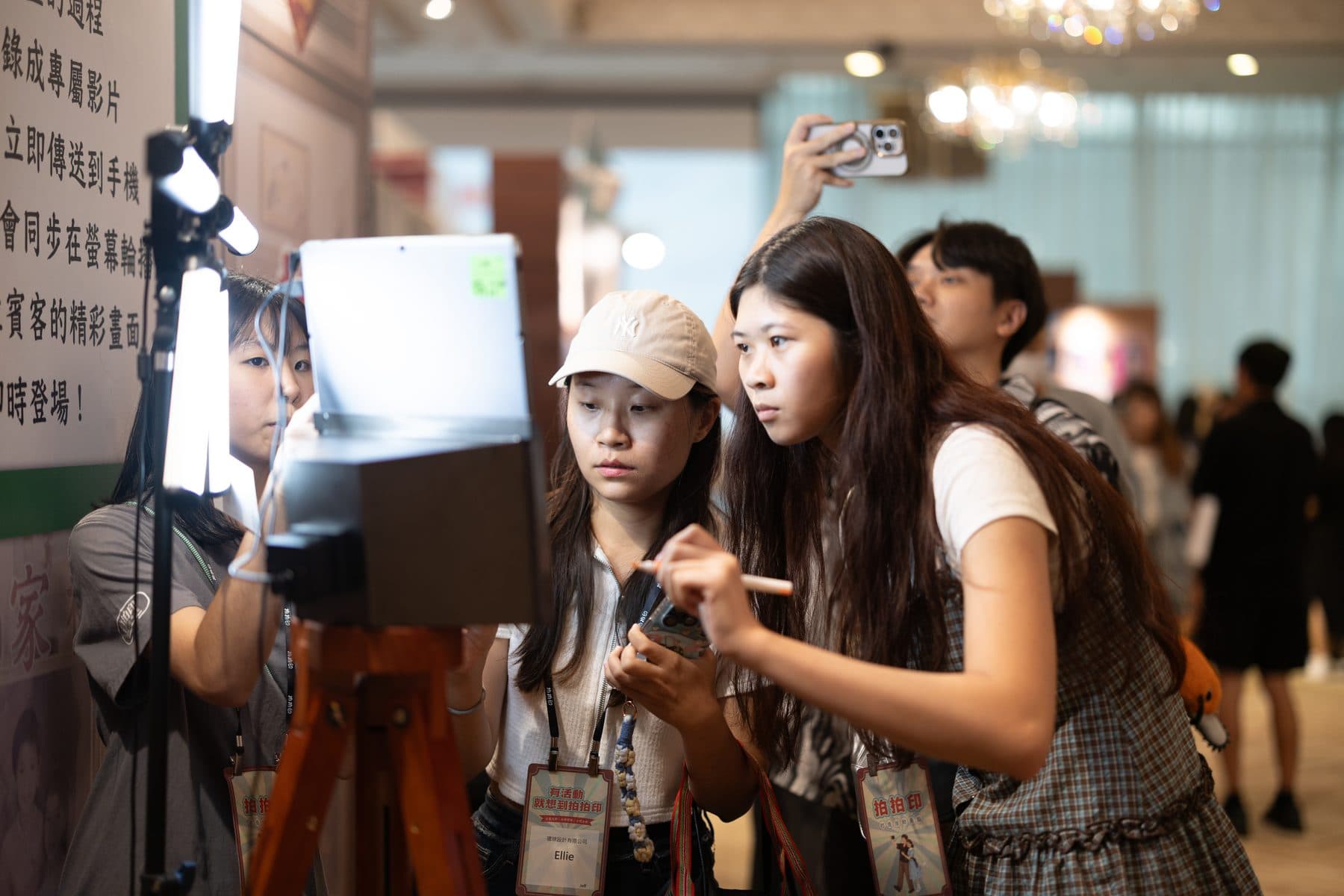 Several guests gathered around the booth using it at once