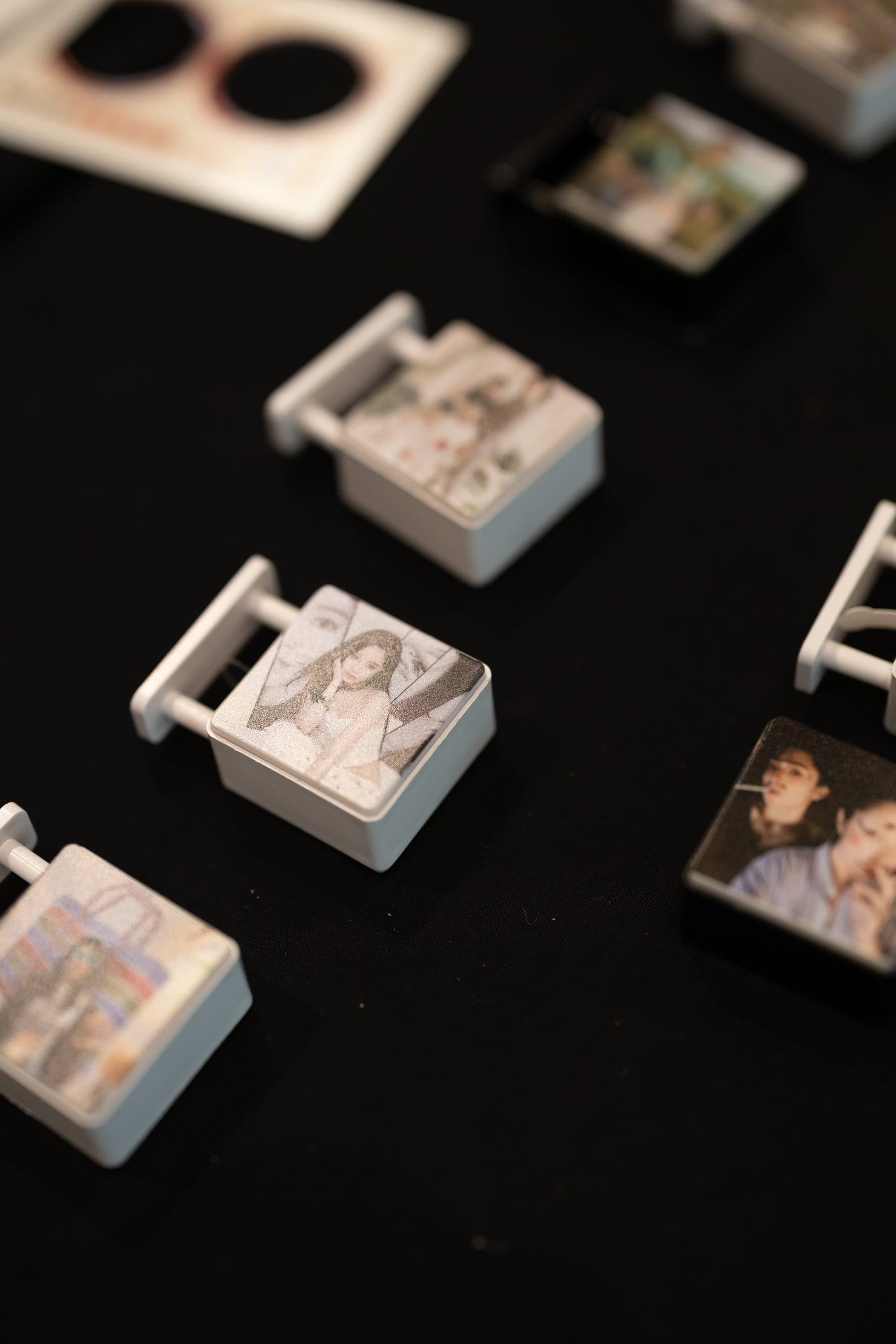 Finished LED magnetic lightboxes scattered on a black table, panels printed with portraits and pets