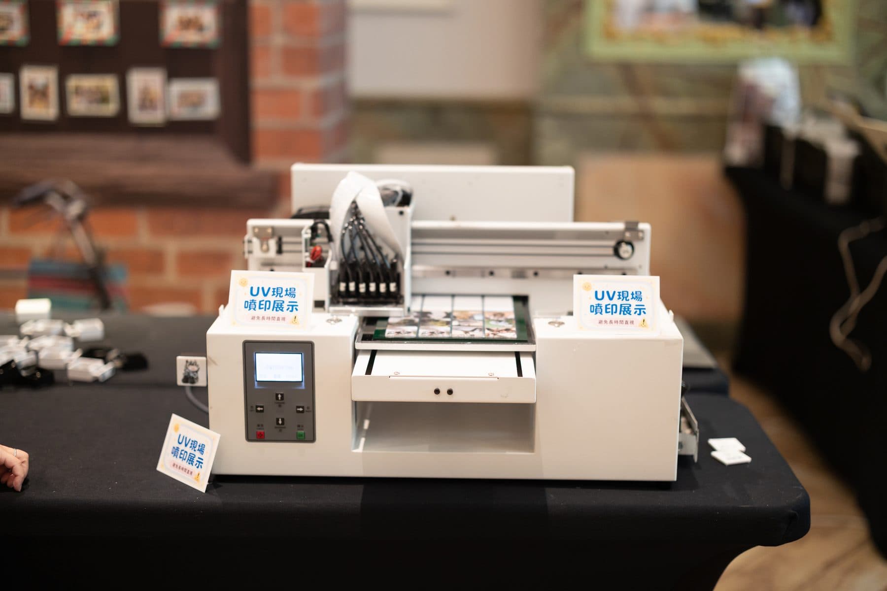 The desktop UV flatbed printer on site with its live-printing signage