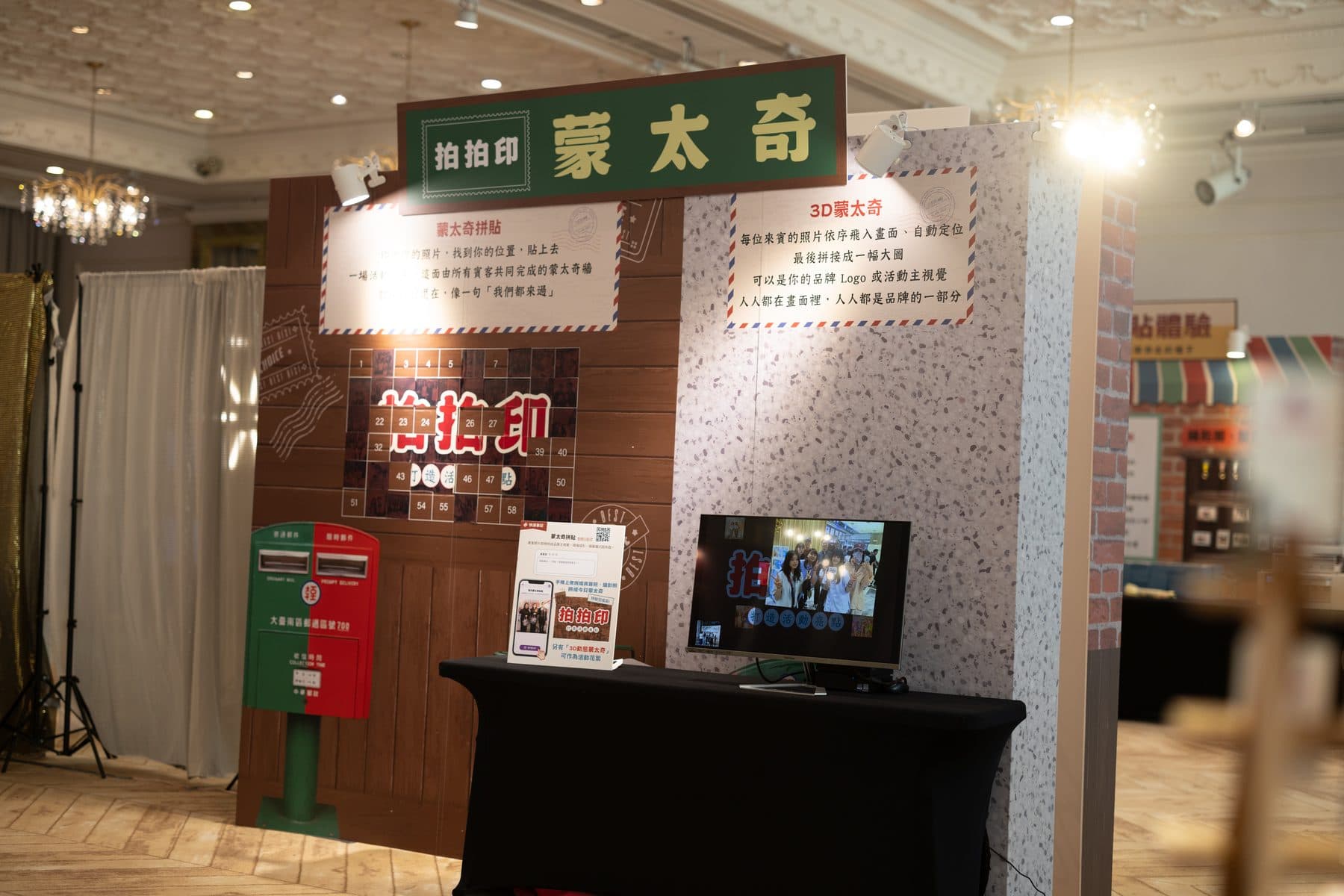 The photo mosaic stand dressed as a retro post office with red and green postboxes and a screen showing the mosaic