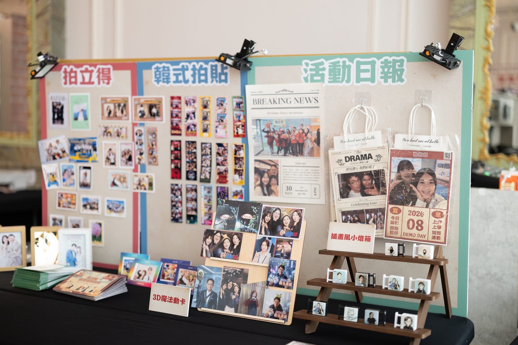 A display wall with instant prints, photo strips and the event newspaper side by side