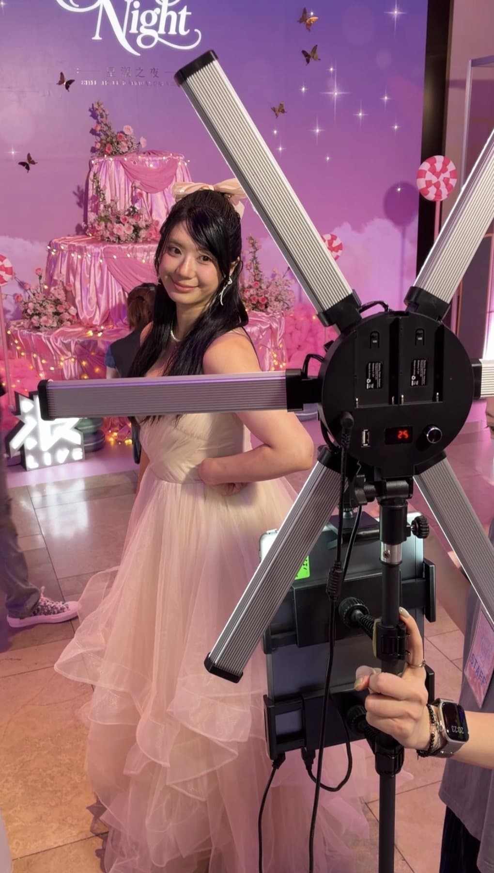 A guest ready to shoot between the light bars, pink dessert-tower backdrop behind