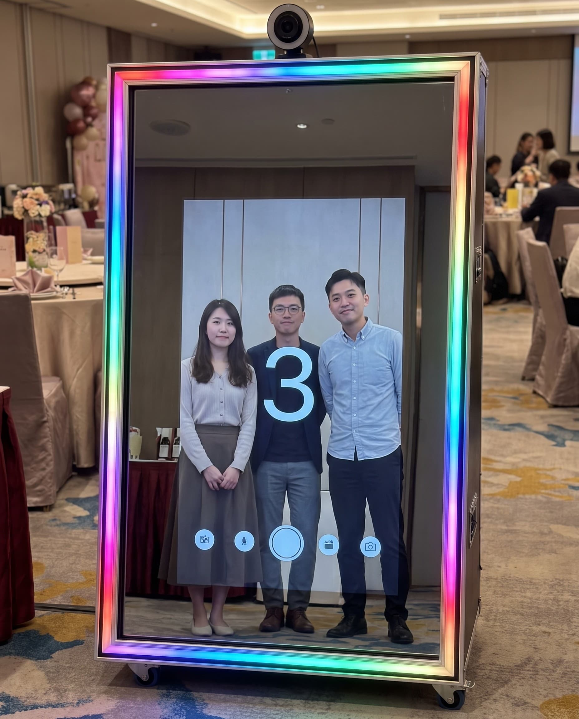 Colleagues laughing in front of the magic mirror at a company party
