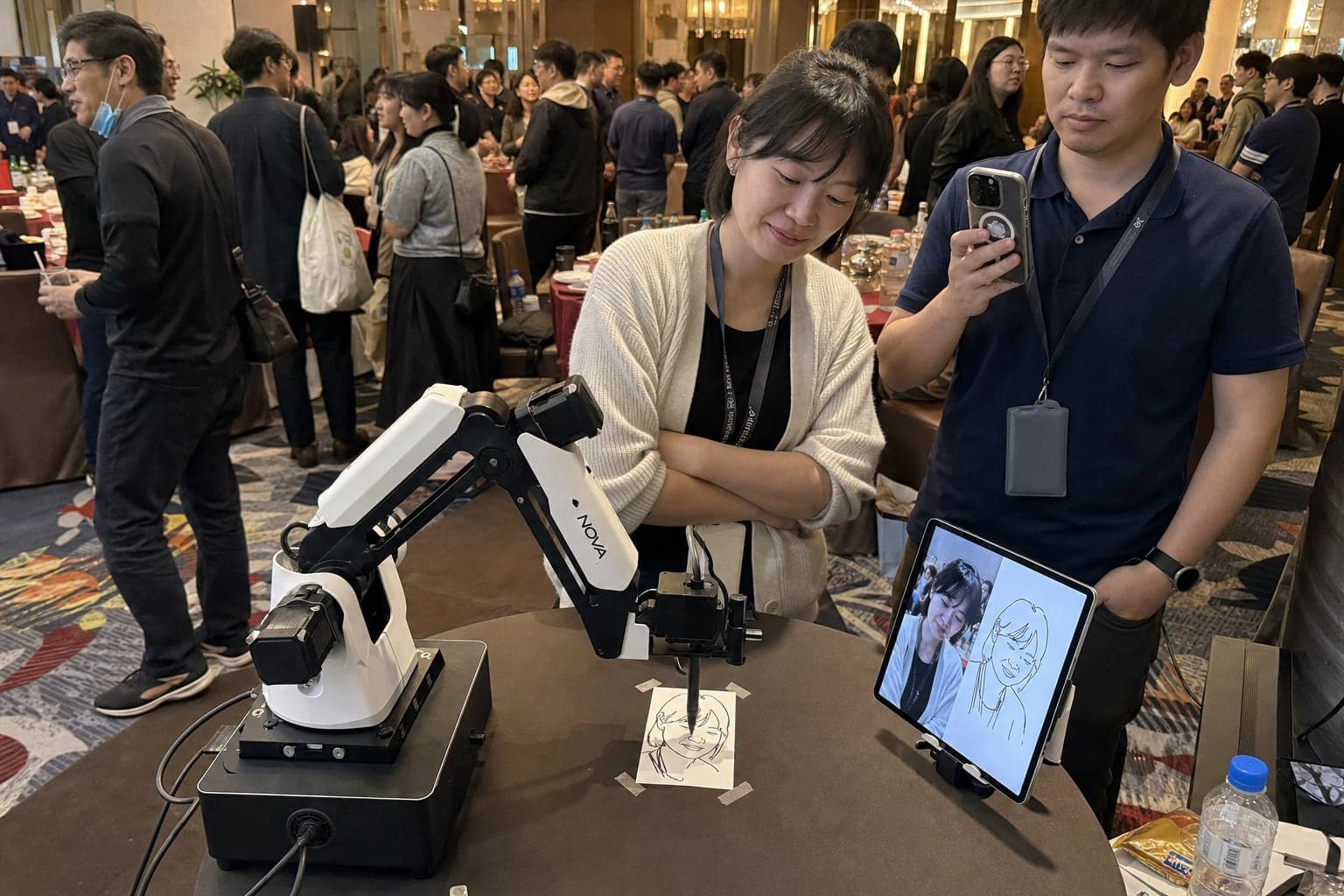 AI sketch robot drawing at a corporate event reception while the guest leans in to watch her portrait appear