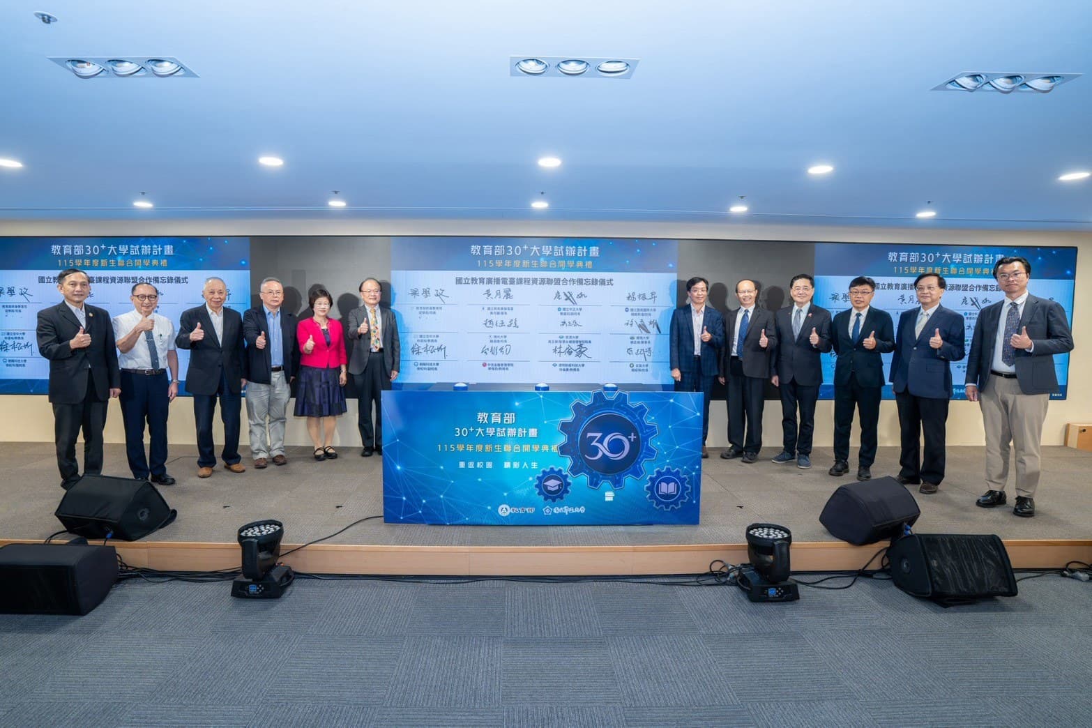 12 VIPs applauding for the group photo in front of the completed wall
