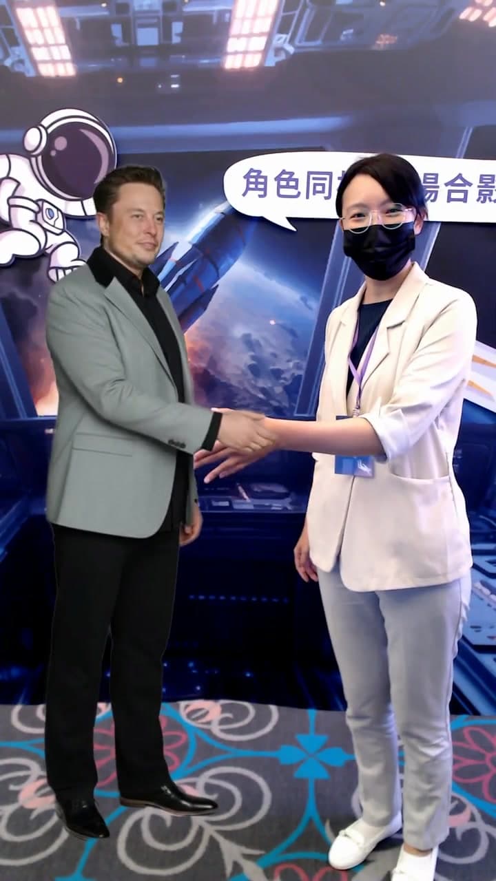 Celebrity photo booth demo: Elon Musk walks into frame beside the guest, shakes hands and poses — the whole clip is recorded