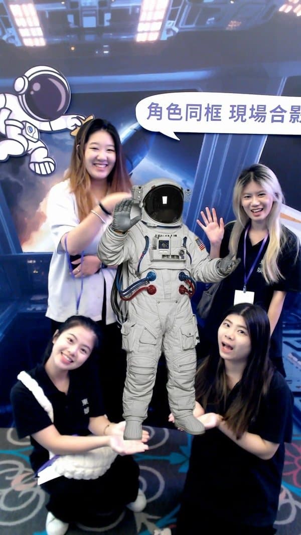 Celebrity & mascot photo booth — a guest high-fives the astronaut character on the big screen