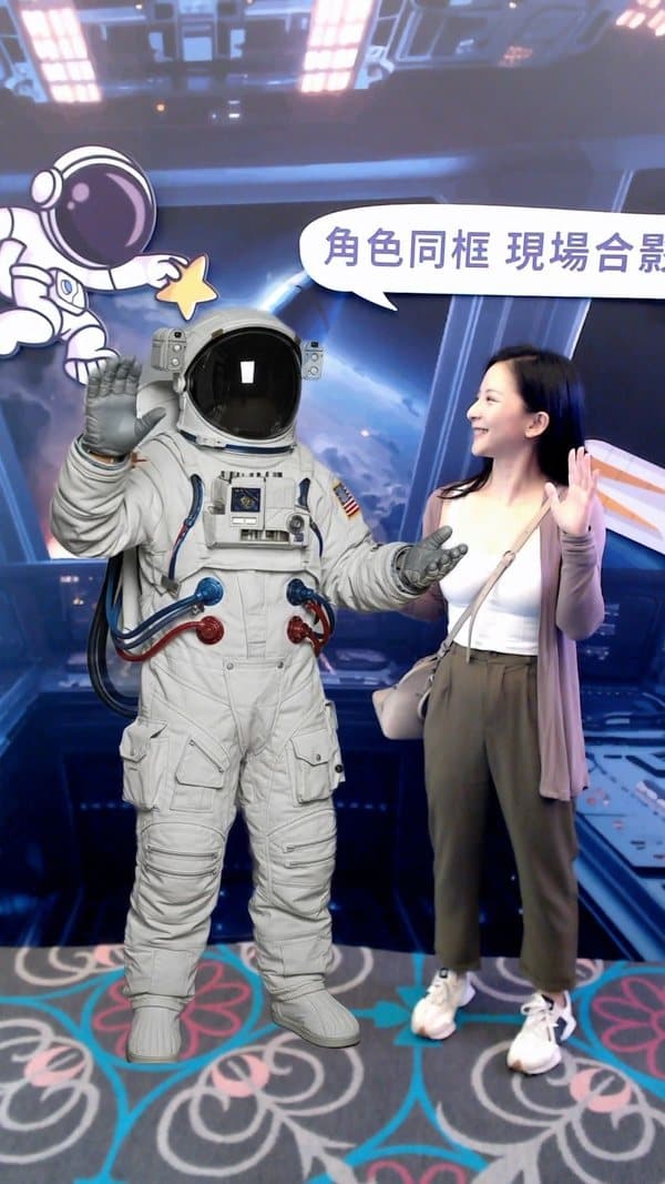 Virtual photo-with — a guest posing for a photo with the astronaut character on the big screen