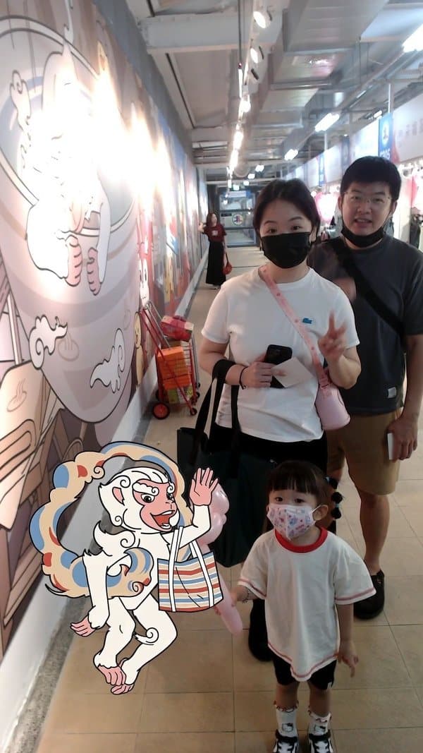 Photo with mascot — a family poses in frame with the illustrated monkey mascot