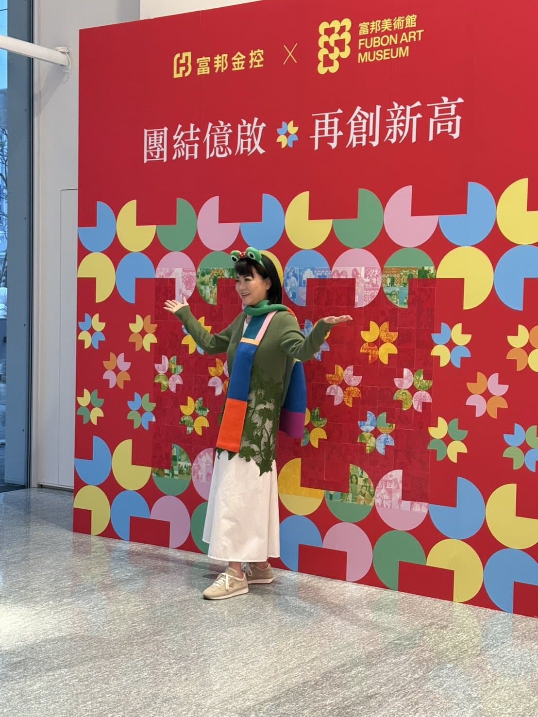 Finished colourful geometric key-visual mosaic wall at an art museum event, with guests posing in front