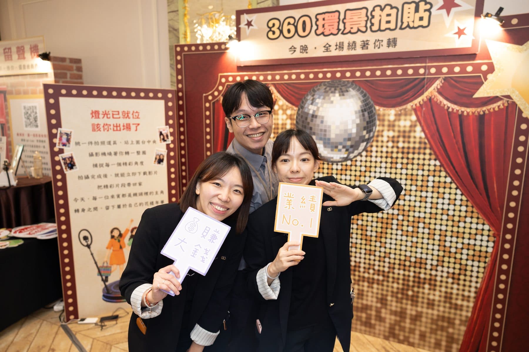 Three guests with illuminated prop signs at the 360 zone in front of a vintage-cinema backdrop