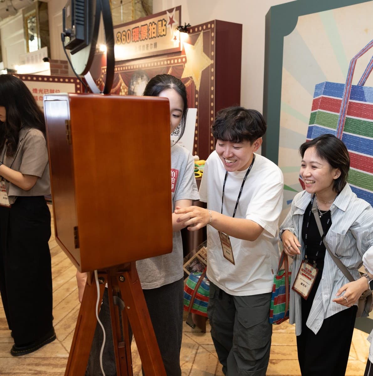 Guests gathered around the vintage wooden AI photo booth, tapping the screen and laughing