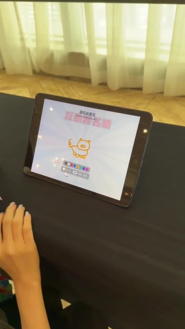A guest signs on the tablet, then the camera pans to the screen where the signature has already appeared