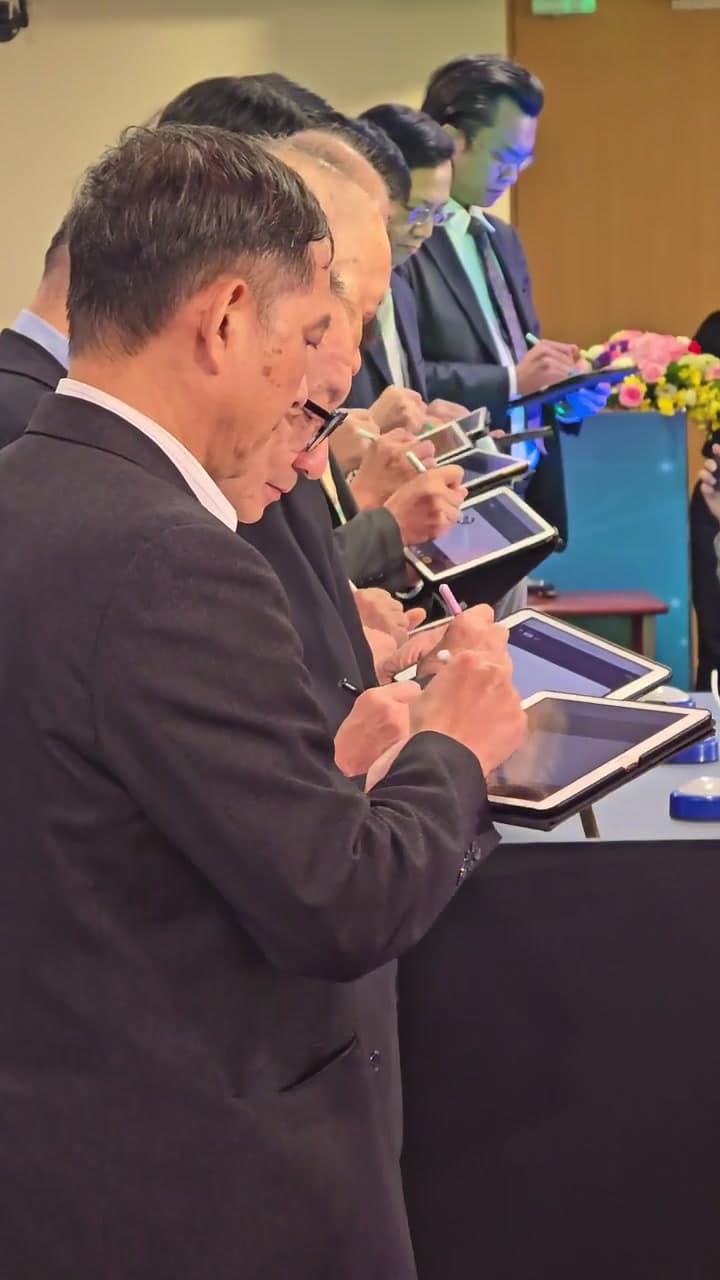 Side close-up: a VIP holding an iPad and signing with a stylus