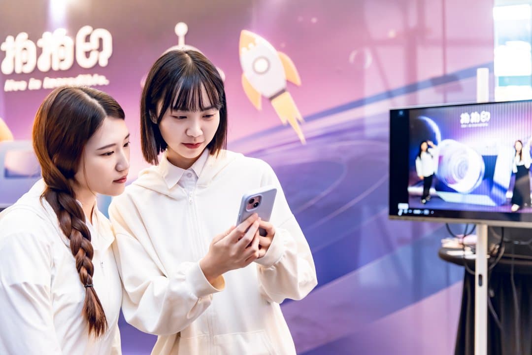 Two guests checking the event system on a phone together